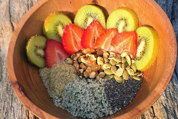 A hand holding a serving of the seed and nut mix